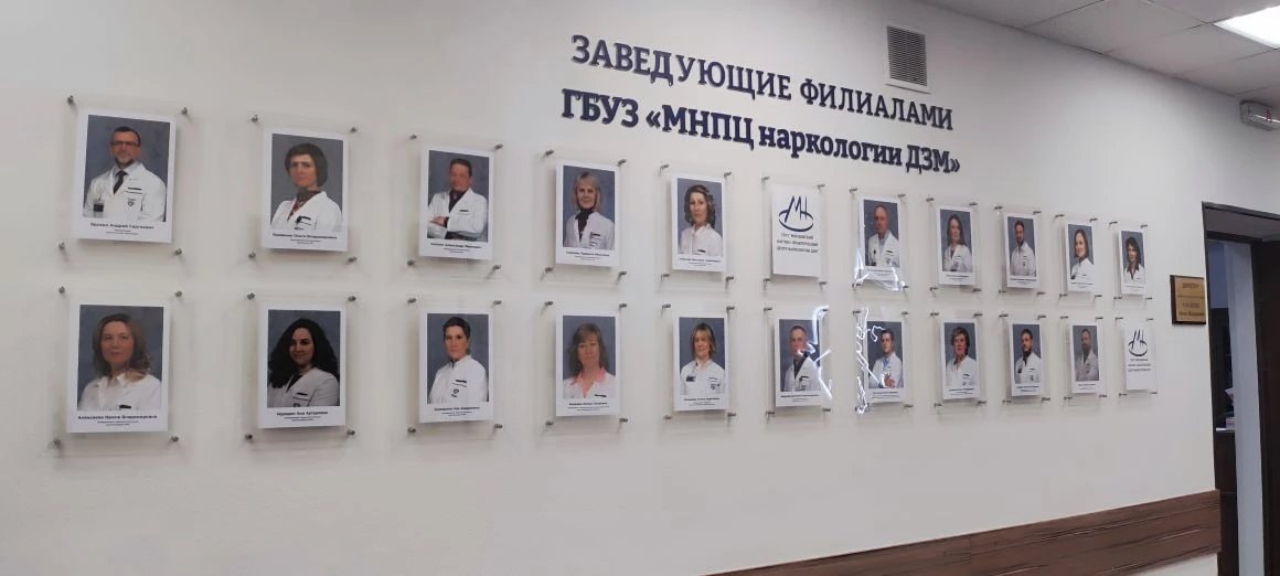 Стена с акриловыми настенными рамками на дистанционных держателях в холле учреждения